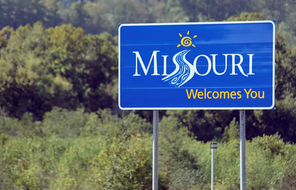 Missouri welcome sign surrounded by trees, featured in the Official RV & Camping Guide.