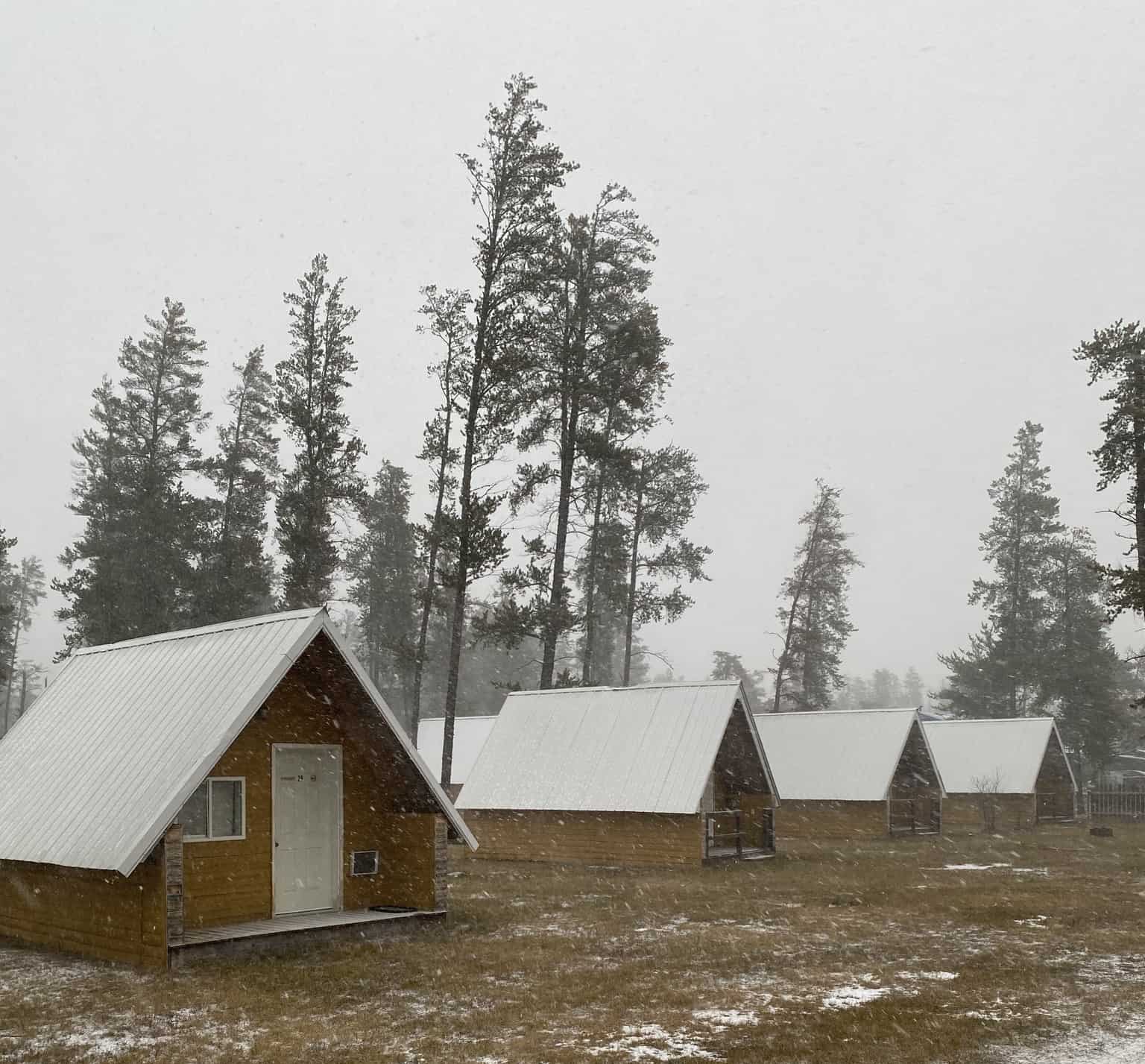 A group of cabins at Woodridge Campground, owned by the campsite's owner, situated in a snowy field.