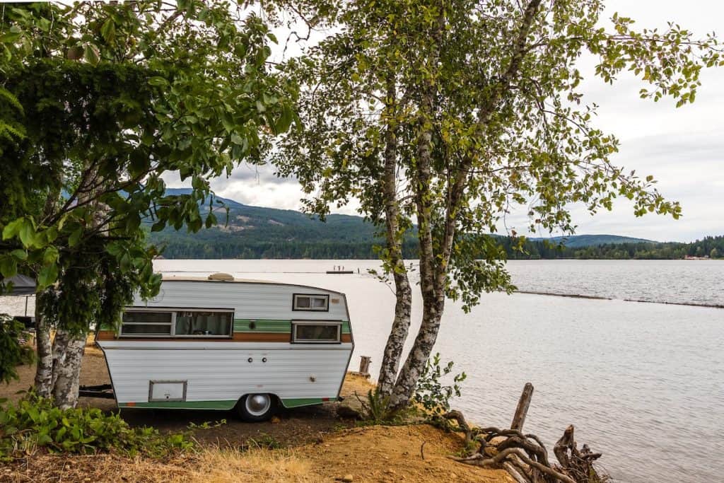 "Reservation Openings available at Cumberland Campground for the upcoming season, offering the perfect spot to park your RV next to a serene body of water.