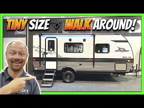 A man is pointing at a stylish and compact Jayco Jay Flight SLX 7 travel trailer.