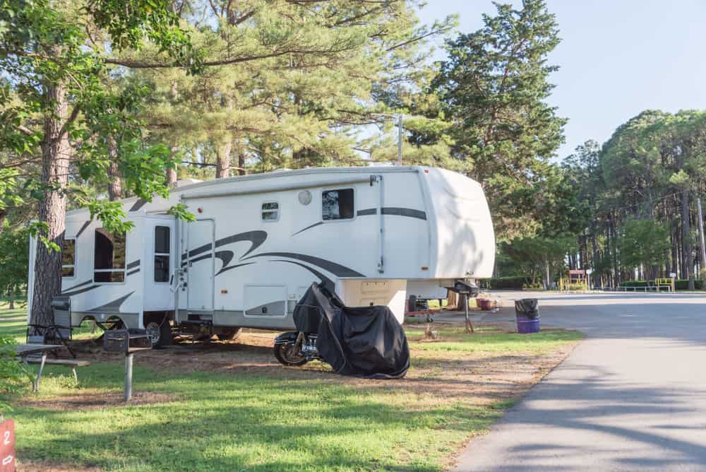 A legal marketing RV parked in a park with trees in the background.