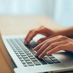 A woman using an AI chatbot on her laptop keyboard for unmatched convenience and instant answers.