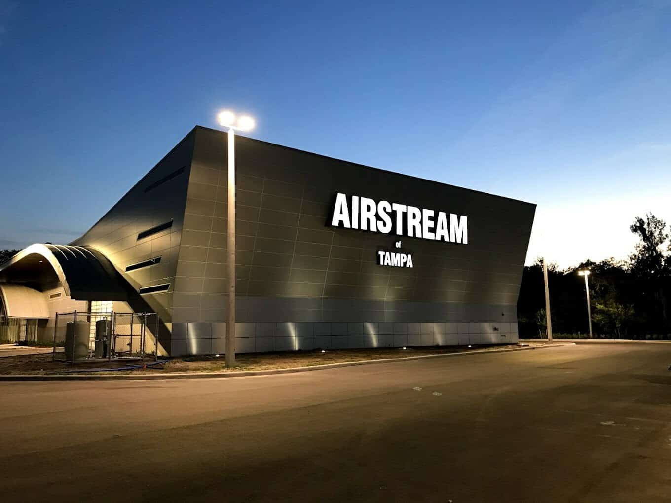 A Blue Compass RV building that says Airstream at dusk, highlighting Airstream's Five Rivet Honors.