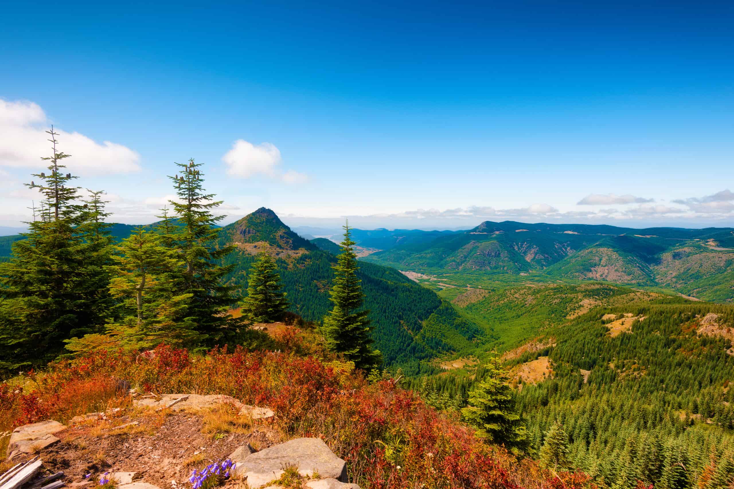 A breathtaking view from the top of a mountain overlooking a serene valley.