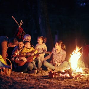 Steve Stafford, Director of Franchise Sales at Yogi Bear's Jellystone Park, overseeing a group of people sitting around a campfire at night.