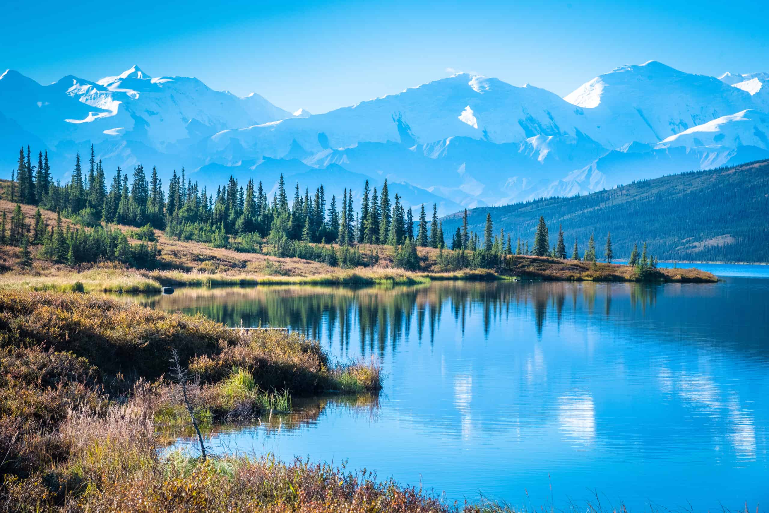 A lake surrounded by mountains and trees in a National Park Service area.