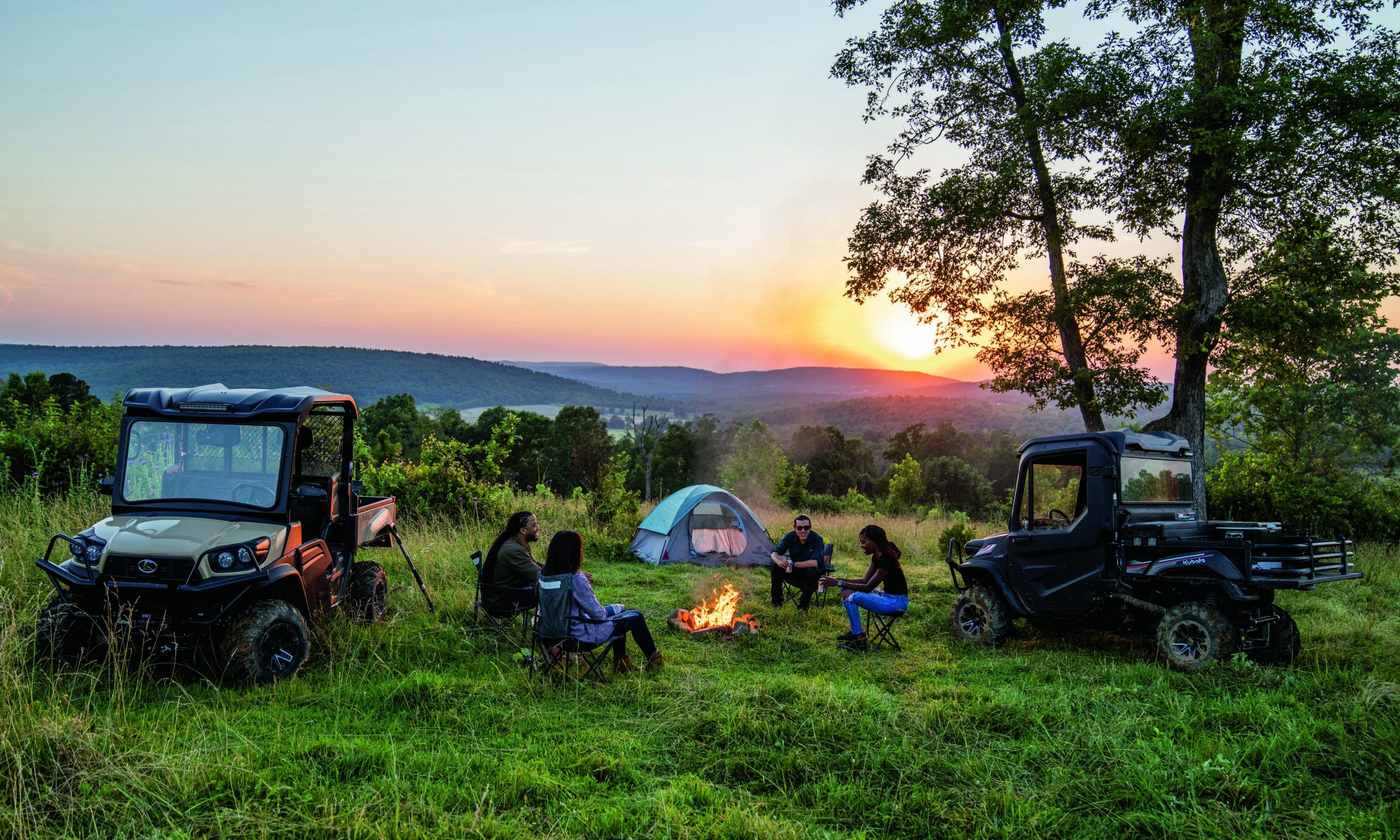 A group of people sitting around a campfire in a field, enjoying the warm glow and sharing stories.