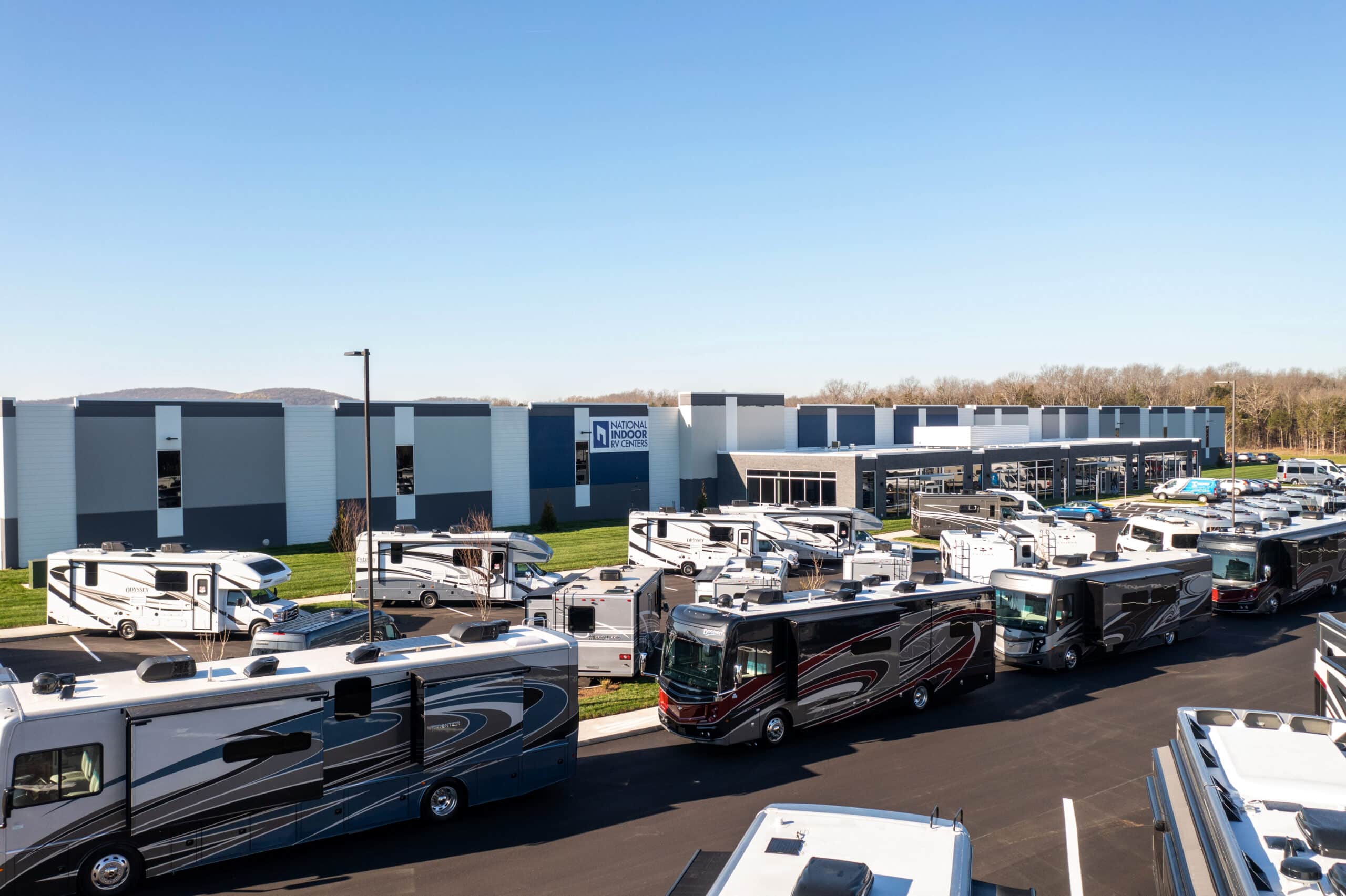 Many NIRVC-branded rvs parked in front of a building at the Nashville RV lifestyle center.