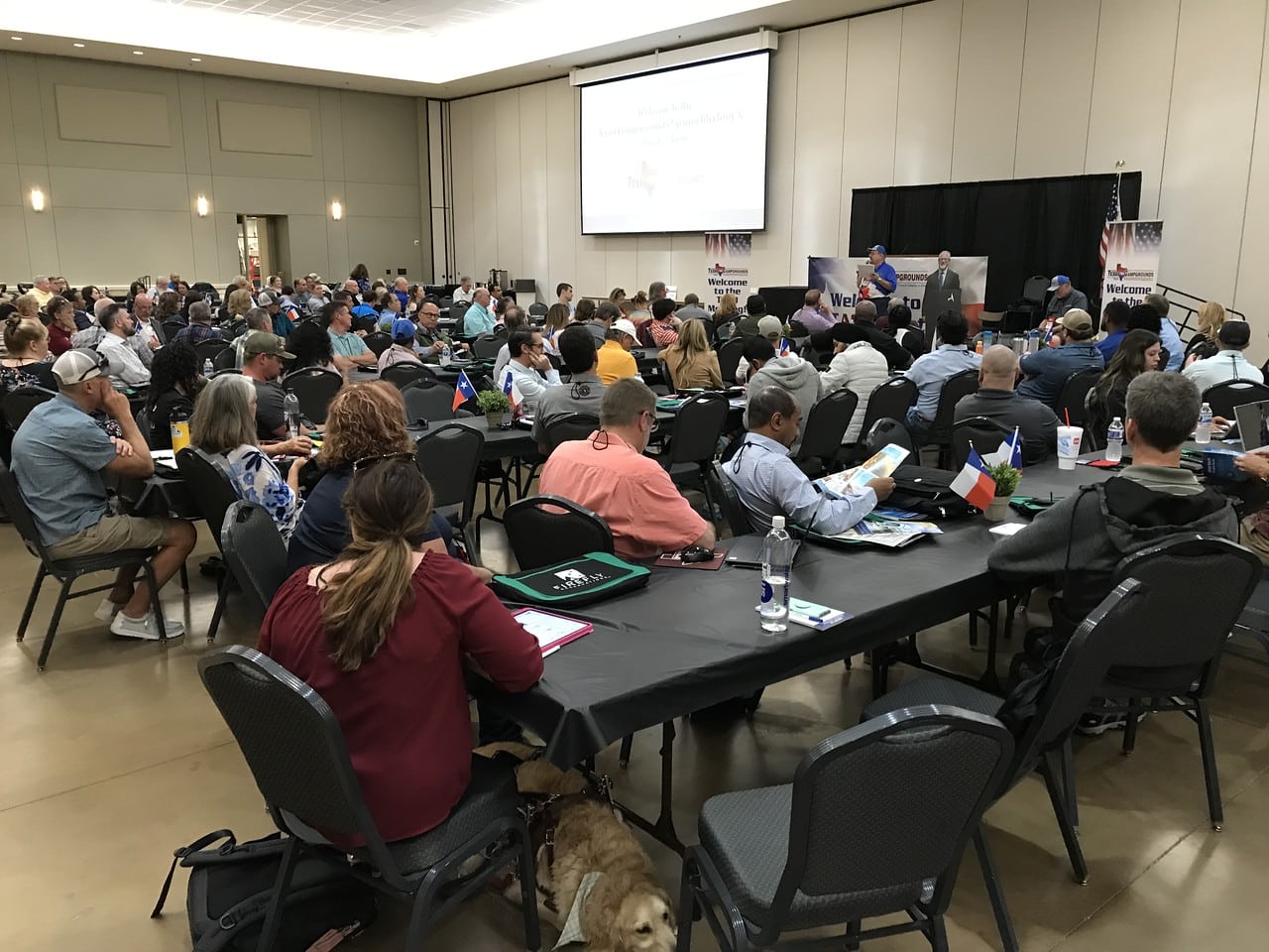 A large group of people sitting at tables in a conference room for the Spring Meeting.