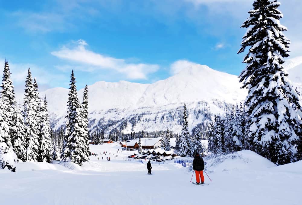 A group of people enjoying a scenic ski down a snow-covered slope at B.C. Resorts while taking advantage of an incredible sale.