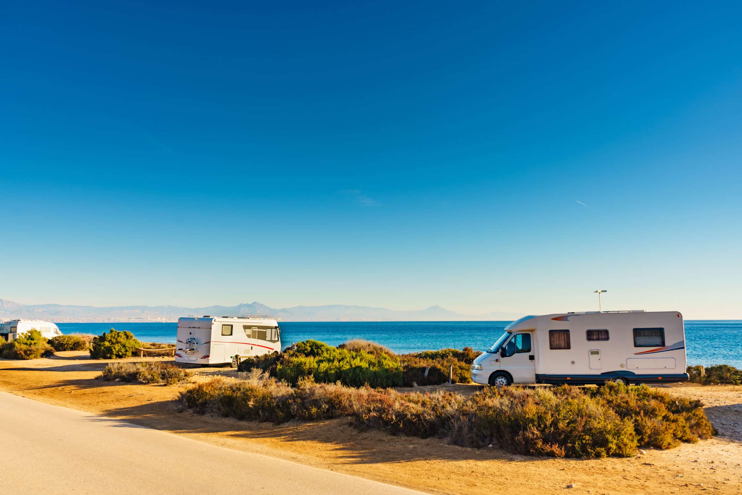 A 200-Lot Recreational Vehicle Resort Development located in Daytona Beach, with a group of rvs parked on a road next to the ocean.