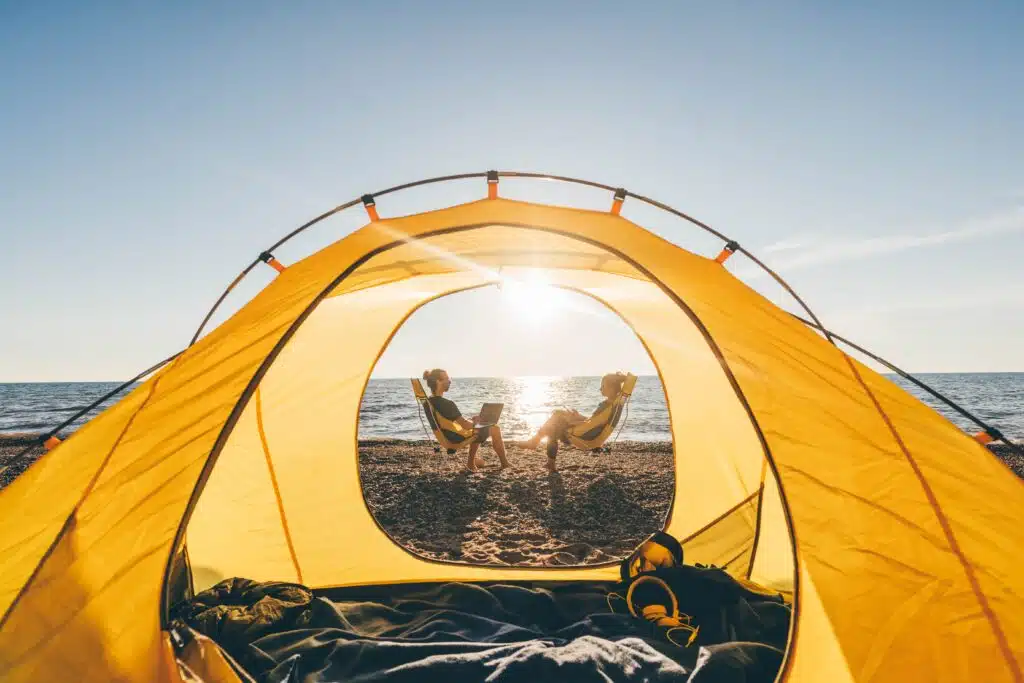 Two people temporarily close a tent on the beach at Bingil Bay Campground for improvement works.