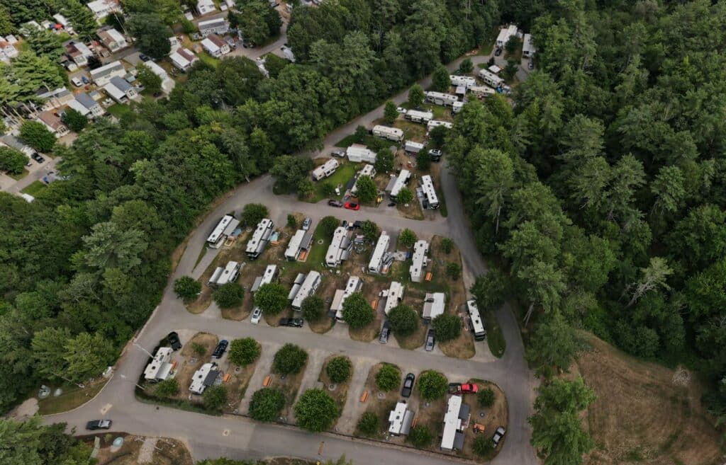 Experience the serene beauty of an rv park nestled amidst towering trees through a captivating aerial view. With the National ARVC's CampSite 360, delight in virtual tour discounts that allow you to