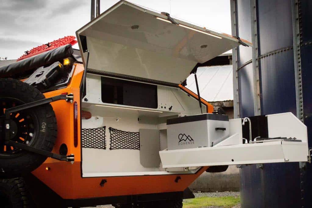 An orange and black Mammoth Overland truck with a storage compartment.