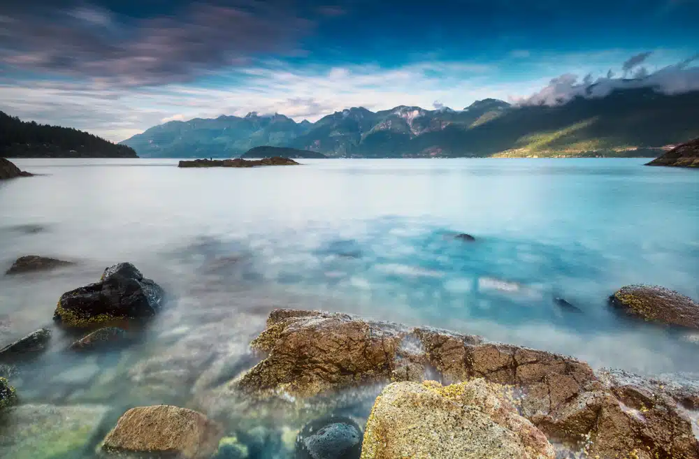 Hidden Gem: A lake with rocks and mountains in the background.