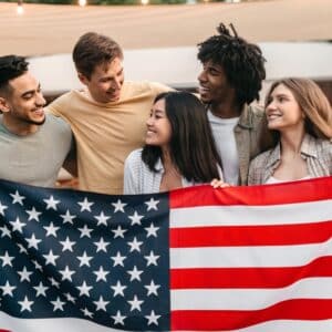 A group of friends holding an American flag during Memorial Day Weekend.