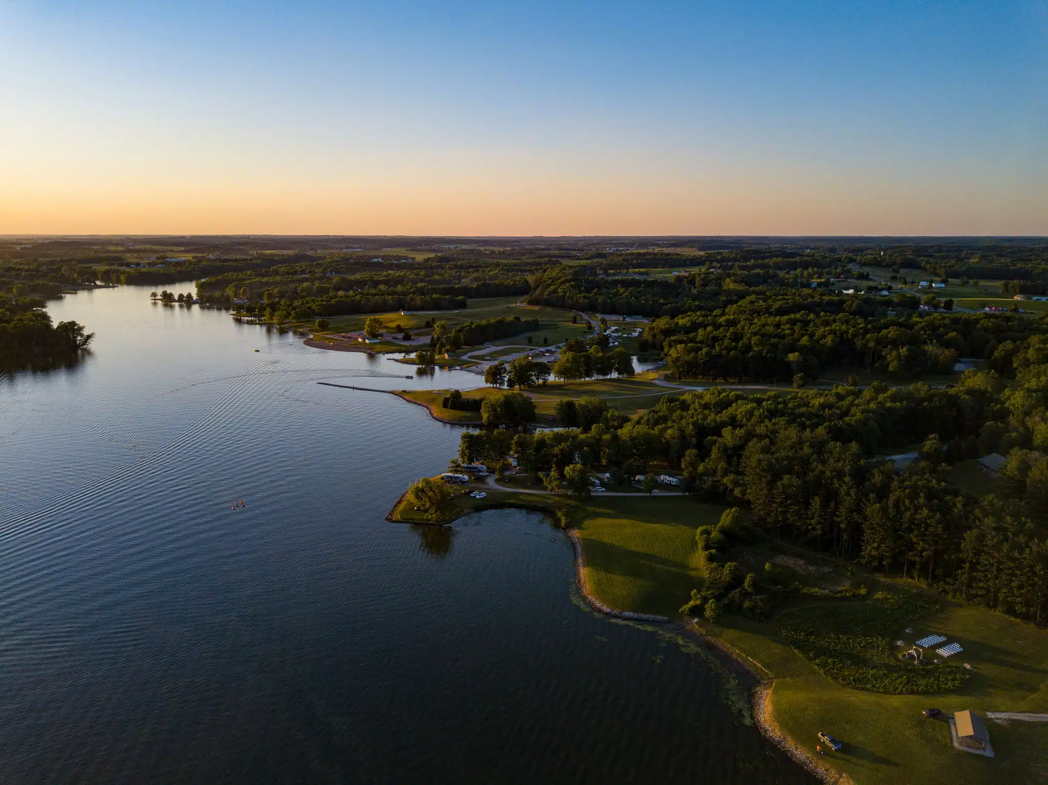 An aerial view of a lake at West Boggs Park during sunset.