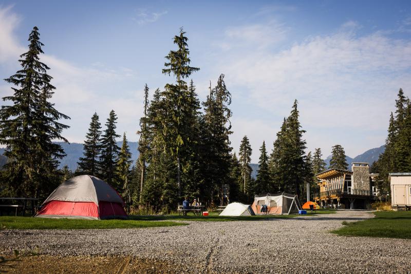 A campground with tents and trees in the background, located near Whistler Olympic Park.