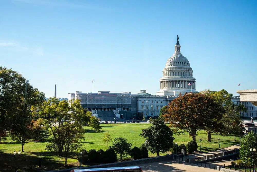 The capitol building is in the background, surrounded by industry leaders and legislation.