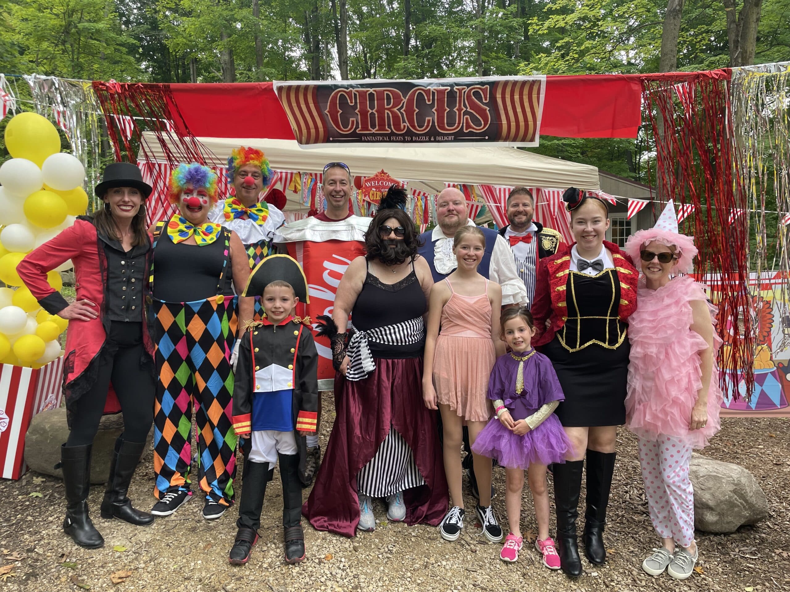 A group of people posing in front of a circus tent at a campground in Wisconsin during autumn.