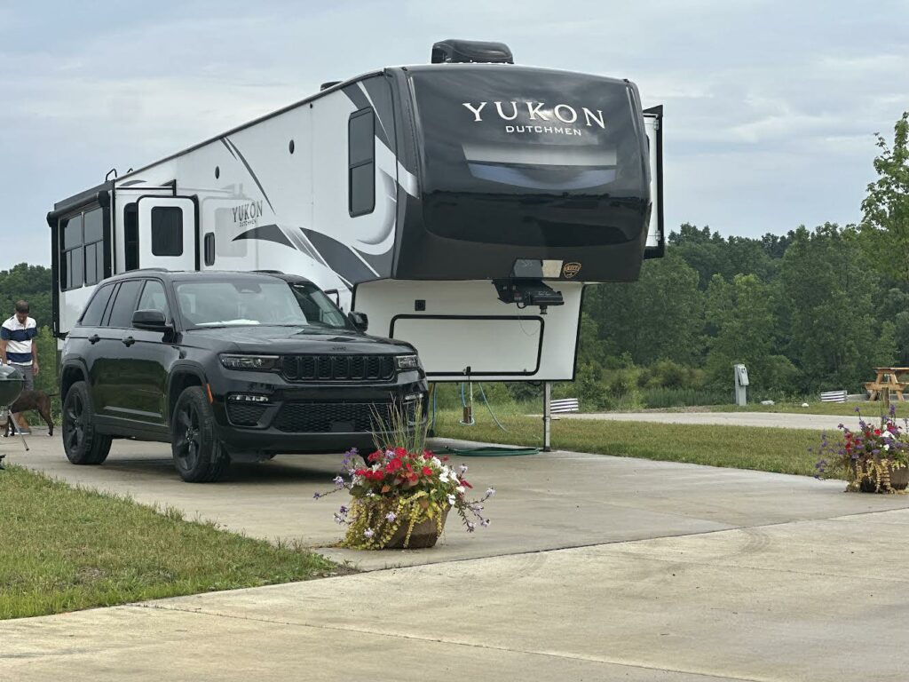 A summertime scene at Hidden Lakes with a jeep parked next to an RV in the resort.