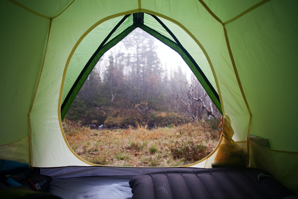 The inside of a tent at a KOA campground with a view of a forest.