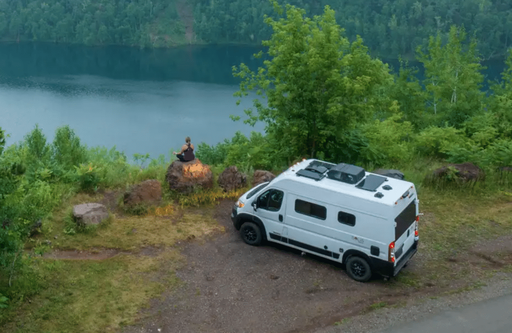 A Winnebago camper van parked next to a lake, equipped with the EcoFlow Solis Pocket for portable power.