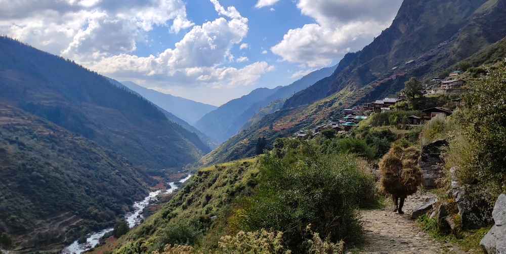 A man is walking down a path in the spiritually enchanting valley of Uttarakhand, also known as Dev Bhoomi.