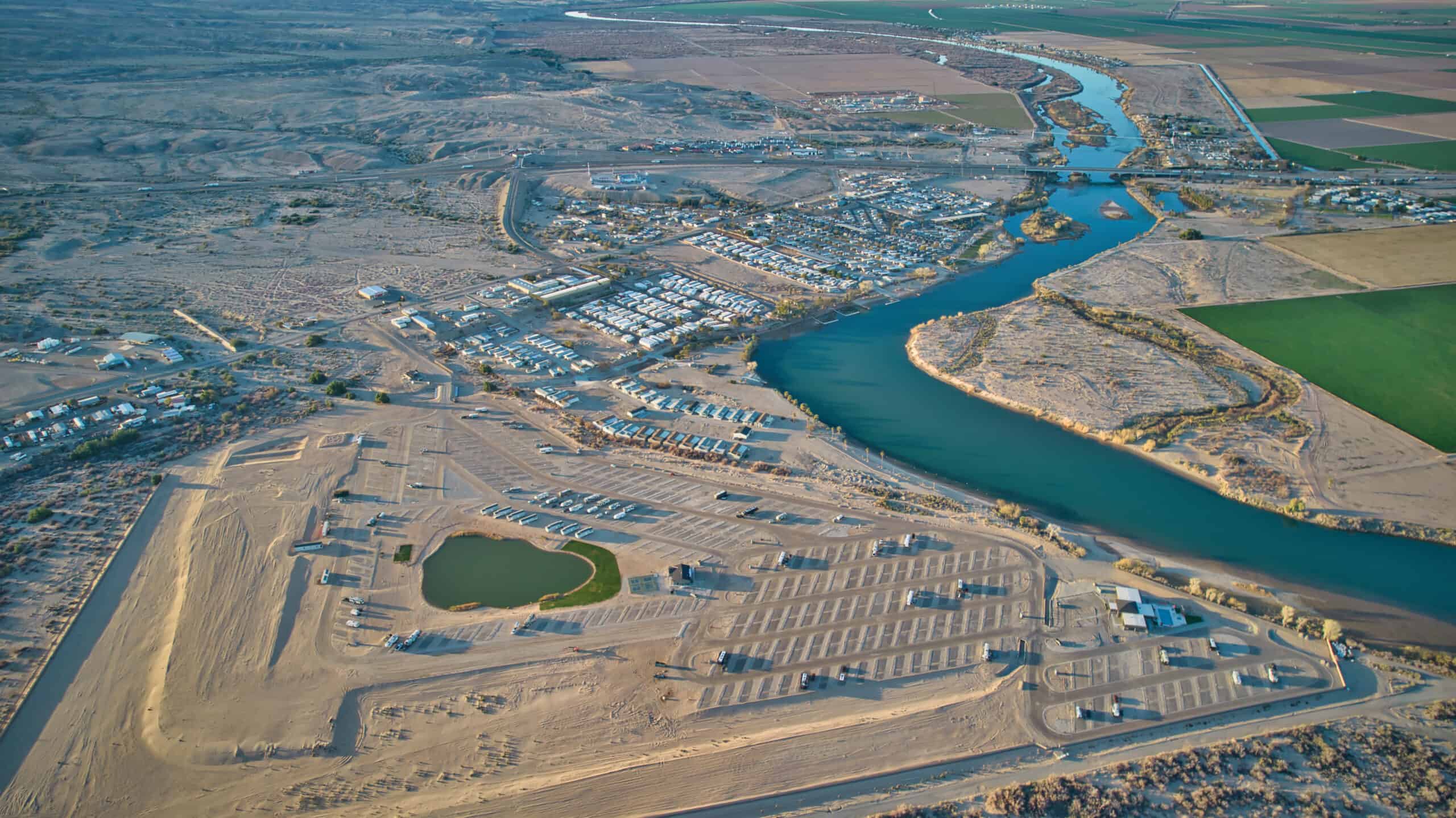 An aerial view of a desert area with a river at the River Sands RV Resort.