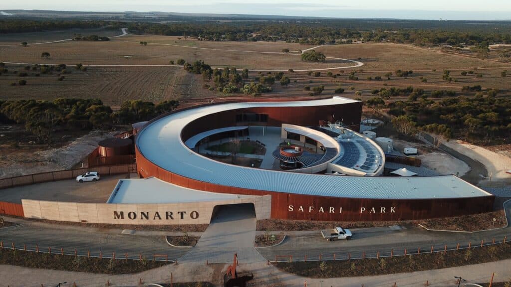 An aerial view of the Monarto Safari Park, showcasing the building with a curved roof as part of the Glamping Project.