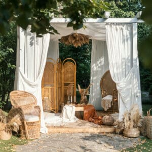 Timber Valley Retreat,Glamping,Wedding Experience is enhanced by a white gazebo adorned with wicker baskets and rattan chairs in a park.