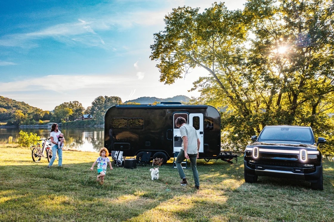 A group of people standing next to a Coast Electric RV.