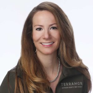 A woman in a green jacket is smiling at the MC Fireside Chats on February 21st, 2024.