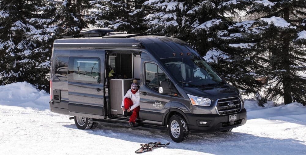 A Safari Condo Ford Transit RV is parked in the snow.