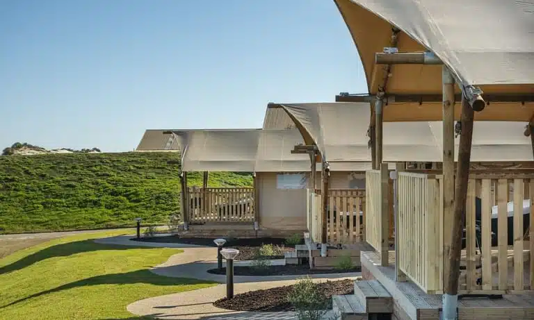 Luxury glamping tents with outdoor amenities under the stars on a grassy landscape in South Australia.