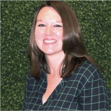 A woman smiling during an MC Fireside Chat in front of a green wall.