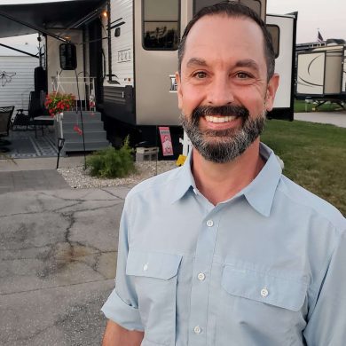 A man smiling in front of an rv park during MC Fireside Chats.